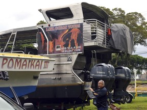 A police officer secures the tour boat "Hot Spot" for the arrival of inspectors in Hilo, Hawaii on May 16, 2018. (AP Photo/John Burnett)