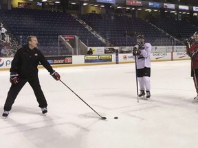 Tim Hunter has been named head coach of Canada's World Juniors national team. Canada's then-assistant coach Tim Hunter, left, addresses, from centre left to right, Cale Makar, Dennis Cholowski and Josh Mahura, all players who hope to make the World Juniors Team, on the first day of Team Canada's selection camp in St. Catharines, Ont., on December 12, 2017. (The Canadian Press/AP-John Wawrow)