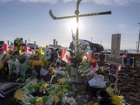 Hockey sticks, messages and other items continue to be added to a memorial at the intersection of a fatal bus crash that killed 16 members of the Humboldt Broncos hockey near Tisdale, Sask. on Saturday, April 14, 2018. (THE CANADIAN PRESS/Liam Richards)