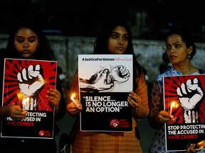In this April 16, 2018 file photo, Indian women hold candles and placards during a protest against recently reported rape cases, in Ahmadabad, India. (AP Photo/Ajit Solanki, File)