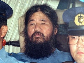 FILE - In this Sept. 25, 1995, file photo, Japanese doomsday cult leader Shoko Asahara, center, sits in a police van following an interrogation in Tokyo. Japanese media reports say on Friday, July 6, 2018, Asahara, who has been on death row for masterminding the 1995 deadly Tokyo subway gassing and other crimes, has been executed. He was 63. (Kyodo News via AP, File) ORG XMIT: TKTT801