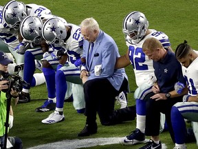 In this Monday, Sept. 25, 2017, file photo, the Dallas Cowboys, led by owner Jerry Jones, take a knee prior to the national anthem in Glendale, Ariz.  (AP Photo/Matt York, File)