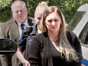 In a Friday July 13, 2018 photo, Samantha Jones, 30, is led into Magisterial Judge Jean Seaman's District Court in Warwick Township, Pa.,for her arraignment on homicide charges of killing her 11-month-old son through her drug-laced breast milk.