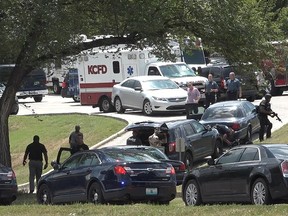 Authorities mobilize near 27th Street and Van Brunt Boulevard after three police officers were shot Sunday, July 15, 2018, in Kansas City, Mo., while trying to arrest a person of interest in the shooting death of a university student on July 6. (Tammy Ljungblad/The Kansas City Star via AP)