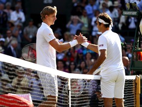 Kevin Anderson of South Africa and Roger Federer of Switzerland embrace at the net following their quarterfinal match at Wimbledon on Wednesday, July 11, 2018 in London, England.