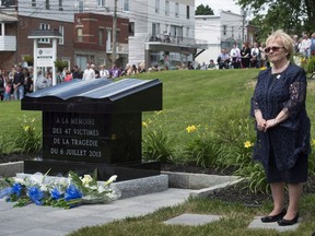Mayor Colette Roy Laroche stands next to the monument in memory of the 47 victims of an oil-filled train derailment a year ago in front of Ste-Agnes in Lac-Megantic, Que., on July 6, 2014. (The Canadian Press/Paul Chiasson)
