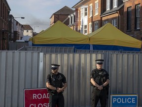 Police secure a point of interest in Salisbury, where counter-terrorism officers are investigating after a woman and her partner were exposed to the nerve agent Novichok, Monday July 9, 2018. (AP Photo/Steve Parsons)