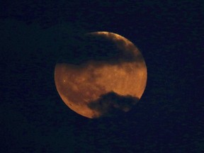 A blood moon rises over Tel Aviv, Israel, Friday, July 27, 2018.