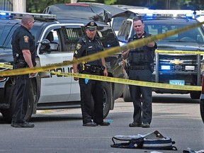 Officers work at the scene where a Weymouth police officer was shot and critically wounded while in a foot chase with a suspect following a vehicle crash on Sunday, July 15, 2018, in Weymouth, Mass.