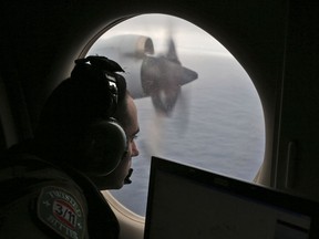 Flight officer Rayan Gharazeddine scans the water in the southern Indian Ocean off Australia from a Royal Australian Air Force AP-3C Orion during a search for the missing Malaysia Airlines Flight MH370 on March 22, 2014. (AP Photo/Rob Griffith)