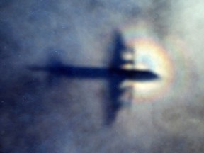 The shadow of a Royal New Zealand Air Force P3 Orion is seen on low level cloud while the aircraft searches for missing Malaysia Airlines Flight MH370 in the southern Indian Ocean, near the coast of Western Australia, on March 31, 2014. (AP Photo/Rob Griffith)