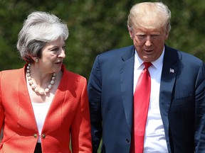 British Prime Minister Theresa May walks with U.S President Donald Trump prior to a joint press conference at Chequers, in Buckinghamshire, England, Friday, July 13, 2018.