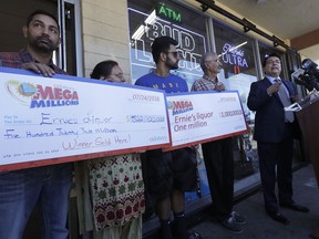 California Lottery deputy director of communications Russ Lopez, right, speaks during a news conference with Vishal Birly, from left, Kiran Sachdev, Amol Sachdev and Ernie's Liquors owner Kewal Sachdev in San Jose, Calif., Wednesday, July 25, 2018.