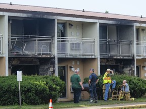Officials investigate at a fire at the Cosmo Extended Stay Motel in Sodus Township, Mich., on Saturday, July 28, 2018.