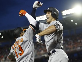 New York Yankees outfielder Aaron Judge (99) celebrates his solo home run with Baltimore Orioles shortstop Manny Machado (13) during the first inning Major League Baseball All-star Game, Tuesday, July 17, 2018 in Washington.