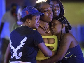 People react at the scene of a shooting in New Orleans, Saturday, July 28, 2018.