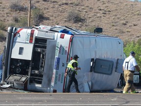 Emergency personnel work at the scene of a deadly multi-vehicle crash involving a bus that occurred on Interstate 25 north of Bernalillo, N.M., on Sunday, July 15, 2018. (Greg Sorber/The Albuquerque Journal via AP)