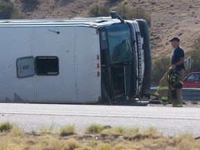 An officer works at the scene of a deadly multi-vehicle crash involving a bus that occurred on Interstate 25, north of Bernalillo, N.M., on Sunday, July 15, 2018. (Greg Sorber/The Albuquerque Journal via AP)