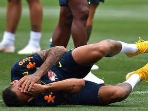 Brazil forward Neymar gestures as he lies on the ground during a training session at Yug Sport Stadium, in Sochi, on July 4, 2018, during the 2018 World Cup. (Getty Images)