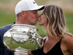 Alex Noren of Sweden, holding the trophy, kisses his wife Jennifer Noren after he won the French Open de France Golf tournament at the Albatros Course in Guyancourt, south west of Paris, France.