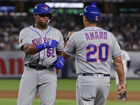 New York Mets' Yoenis Cespedes (52) is congratulated by first base coach Ruben Amaro Jr. (20) Friday, July 20, 2018, in New York.