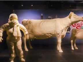 This Monday, July 16, 2018, photo provided by the American Dairy Association Mideast shows Ohio State Fair butter sculptures including this year's sculptures marking the 35th anniversary of the 1983 movie "A Christmas Story," including the character Randy who "can't put my arms down" due to his bulky snowsuit, left, and the display's customary cow and calf, right, in the Dairy Products Building at The Ohio Expo Center & State Fair in Columbus, Ohio. The American Dairy Association Mideast says sculptors spent more than 400 hours creating the refrigerated display unveiled Tuesday, July 24, 2018, crafted from more than a ton of butter.