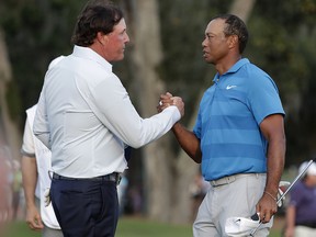 In this May 10, 2018, file photo, Phil Mickelson, left, and Tiger Woods shake hands after the first round of the Players Championship, in Ponte Vedra Beach, Fla. (AP Photo/Lynne Sladky, File)