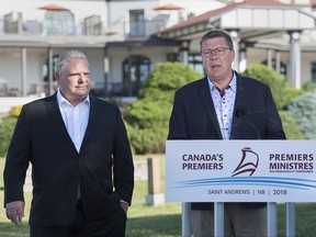 Ontario Premier Rob Ford, left, and Saskatchewan Premier Scott Moe talk with reporters as the Canadian premiers meet in St. Andrews, N.B. on Thursday, July 19, 2018. (The Canadian Press/Andrew Vaughan)