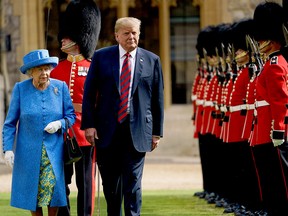 U.S. President Donald Trump is accompanied by Queen Elizabeth II as he inspects the Guard of Honour at Windsor Castle in Windsor, west of London, on July 13, 2018 on the second day of Trump's U.K. visit.