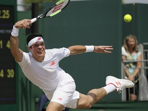 Milos Raonic returns a ball to Dennis Novak during Wimbledon in London, Saturday July 7, 2018. (AP Photo/Tim Ireland)