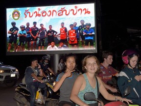 Motorists pass a billboard with a photograph showing members of the Thai children's football team "Wild Boar" and their coach with a message "welcome home brothers" displayed in Chiang Rai as the boys and their coach were all rescued in the Tham Luang cave in Khun Nam Nang Non Forest Park in the Mae Sai district on July 10, 2018.