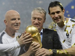 France head coach Didier Deschamps, second right, holds the trophy at the end of the final match between France and Croatia at the 2018 soccer World Cup in the Luzhniki Stadium in Moscow, Russia, Sunday, July 15, 2018. (AP Photo/Matthias Schrader)