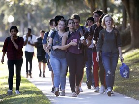 In this Wednesday, Feb. 14, 2018 file photo, groups of students leave Marjory Stoneman Douglas High School in Parkland, Fla.  (AP Photo/Wilfredo Lee, File)