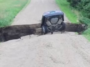 A 16-year-old driver in Minnesota had to climb out the back window of his car after he drove into a sinkhole following heavy rains. (YouTube)