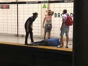 Three men look on after rescuing a blind man that had fallen onto the subway tracks at Broadview Station in Toronto on Thursday, June 28, 2018. A Toronto transit rider credited with saving a man who fell onto the subway tracks said he couldn't have done it without the help of two others who jumped in with him.
