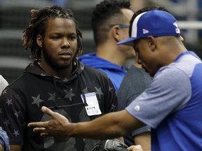 Blue Jays prospect Vladimir Guerrero Jr., left, listens to left fielder Curtis Granderson before a game against the Tampa Bay Rays on June 11, 2018, in St. Petersburg, Fla.