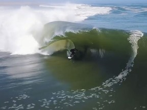 In this image made from video provided by Chris Rogers, surfer Koa Smith rides a wave off the coast of Namibia, on the Western shore of Africa. Smith rode for nearly a mile over a 120-second span and stayed upright as he traveled through eight barrels--the hollow formed by the curve of the wave as it breaks over the surfer's head.