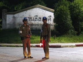 Police man guard a junction for an ambulance believed to be carrying one of the rescued boys from the flooded cave, in the Mae Sai district of Chiang Rai province, northern Thailand, Monday, July 9, 2018.