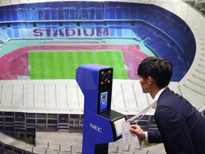 A staff demonstrates a new face recognition system used for the Tokyo 2020 Olympic and Paralympic Games during a press conference in Tokyo Tuesday, Aug. 7, 2018. (AP Photo/Eugene Hoshiko)