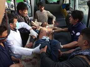 A man who was injured in a deadly suicide bombing that targeted a training class in a private building in the Shiite neighborhood of Dasht-i Barcha is placed in an ambulance in western Kabul, Afghanistan, Wednesday, Aug. 15, 2018.