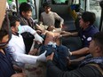 A man who was injured in a deadly suicide bombing that targeted a training class in a private building in the Shiite neighborhood of Dasht-i Barcha is placed in an ambulance in western Kabul, Afghanistan, Wednesday, Aug. 15, 2018.