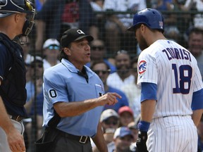 Chicago Cubs' Ben Zobrist, right, argues a strike call with umpire Phil Cuzzi, middle, during the sixth inning of a baseball game, Tuesday, Aug. 14, 2018, in Chicago. (AP Photo/David Banks)
