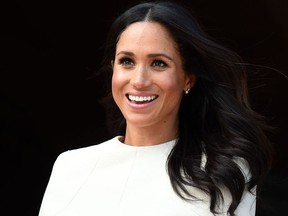 (FILES) In this file photo taken on June 14, 2018 Meghan, Duchess of Sussex greets well-wishers from the balcony of the Chester Town Hall during her visit, with Britain's Queen Elizabeth II, to Chester, Cheshire on June 14, 2018.