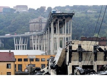 A picture taken on Aug. 14, 2018 shows vehicles standing on a part of a giant motorway bridge after a section collapsed earlier in Genoa, Italy.