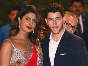 In this file photo taken on June 28, 2018, Indian Bollywood actress Priyanka Chopra (L) accompanied by Nick Jonas arrive for the pre-engagement party of India's richest man and Reliance Industries Limited Chairman, Mukesh Ambanis eldest son Akash Ambani and fiancee Shloka Mehta in Mumbai.