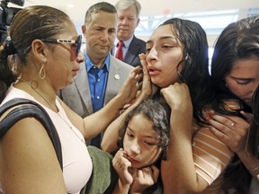 Alejandra Juarez, 39, left, says goodbye to her children, Pamela and  Estela, at the Orlando International Airport on Friday, Aug. 3, 2018 in Orlando, Fla.