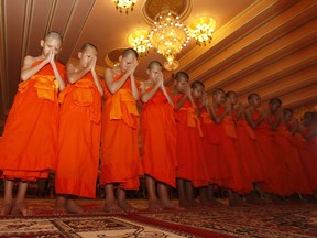Members of Wild Boars soccer team pray during a ceremony marking the completion of their serving as novice Buddhist monks, following their dramatic rescue from a cave in Mae Sai district, Chiang Rai province, northern Thailand, Saturday, Aug. 4, 2018.