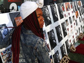 A woman signs a poster outside the Charles H. Wright Museum of African American History during a public visitation for Aretha Franklin in Detroit, Wednesday, Aug. 29, 2018. Franklin died Aug. 16, of pancreatic cancer at the age of 76.