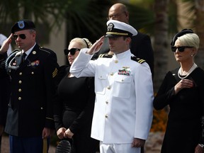 Cindy McCain, right, joined by her sons Jack McCain, and Jimmy McCain, left, and daughter Meghan, second from left, watch as the casket of Sen. John McCain, R-Ariz., is taken from the hearse as they all arrive prior to a memorial service at North Phoenix Baptist Church Thursday, Aug. 30, 2018, in Phoenix.