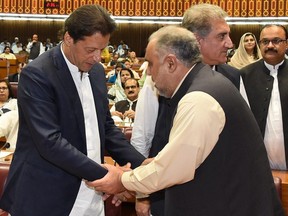 In this photo released by the National Assembly, the leader of Pakistan Tahreek-e-Insaf party Imran Khan, left, greets speaker of the National Assembly Asad Qaiser in Islamabad, Pakistan, Wednesday, Aug. 15, 2018. Pakistan's lower house of parliament elected Qaiser, an ally of Khan, to be its next speaker on Wednesday, paving the way for the former cricket star and longtime politician to become the next prime minister. (National Assembly, via AP)